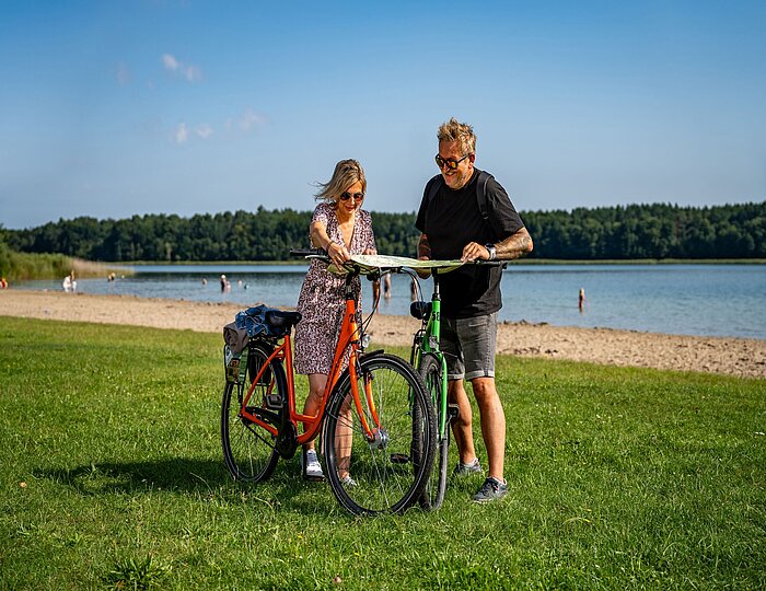 Paar fährt Fahrrad am See