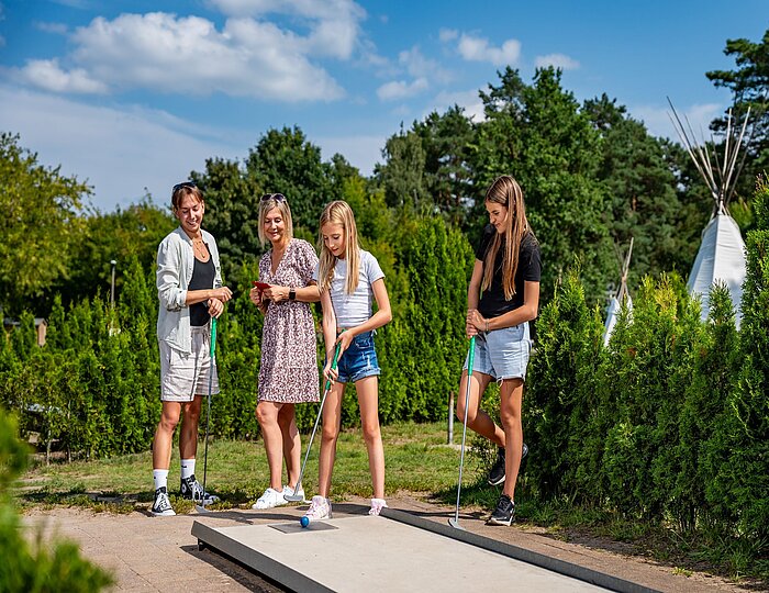 Familie spielt Minigolf