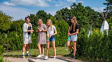Familie spielt Minigolf