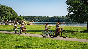 Familie fährt Fahrrad am See