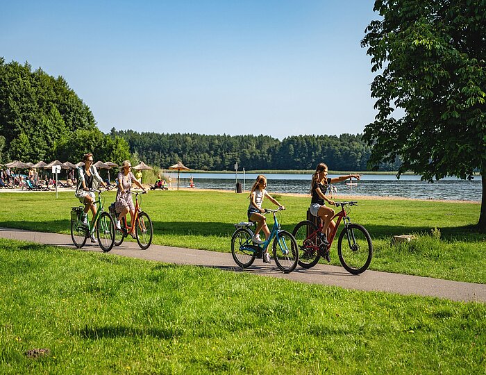 Familie fährt Fahrrad am See